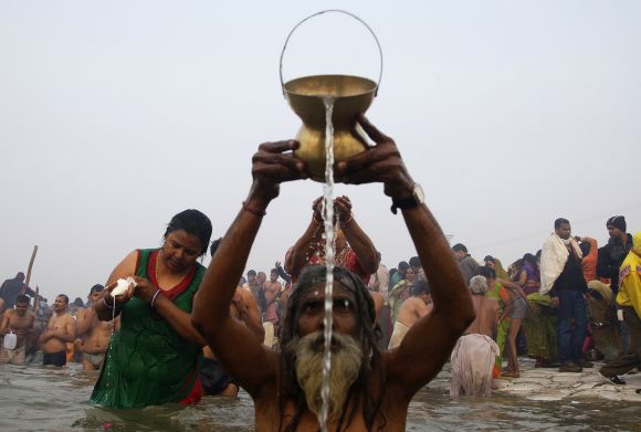 Hindu devotees pray as they attend the first "Shahi Snan" (grand bath) at the ongoing "Kumbh Mela", or Pitcher Festival, in the northern Indian city of Allahabad January 14, 2013. Upwards of a million elated Hindu holy men and pilgrims took a bracing plunge in India's sacred Ganges river to wash away lifetimes of sins on Monday, in a raucous start to an ever-growing religious gathering that is already the world's largest.  REUTERS/Jitendra Prakash (INDIA - Tags: RELIGION SOCIETY)